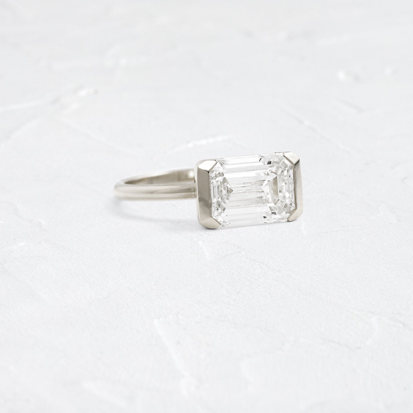 East West Solitaire Half Bezel-Emerald Lab Grown Diamond Engagement Ring - Detail view
