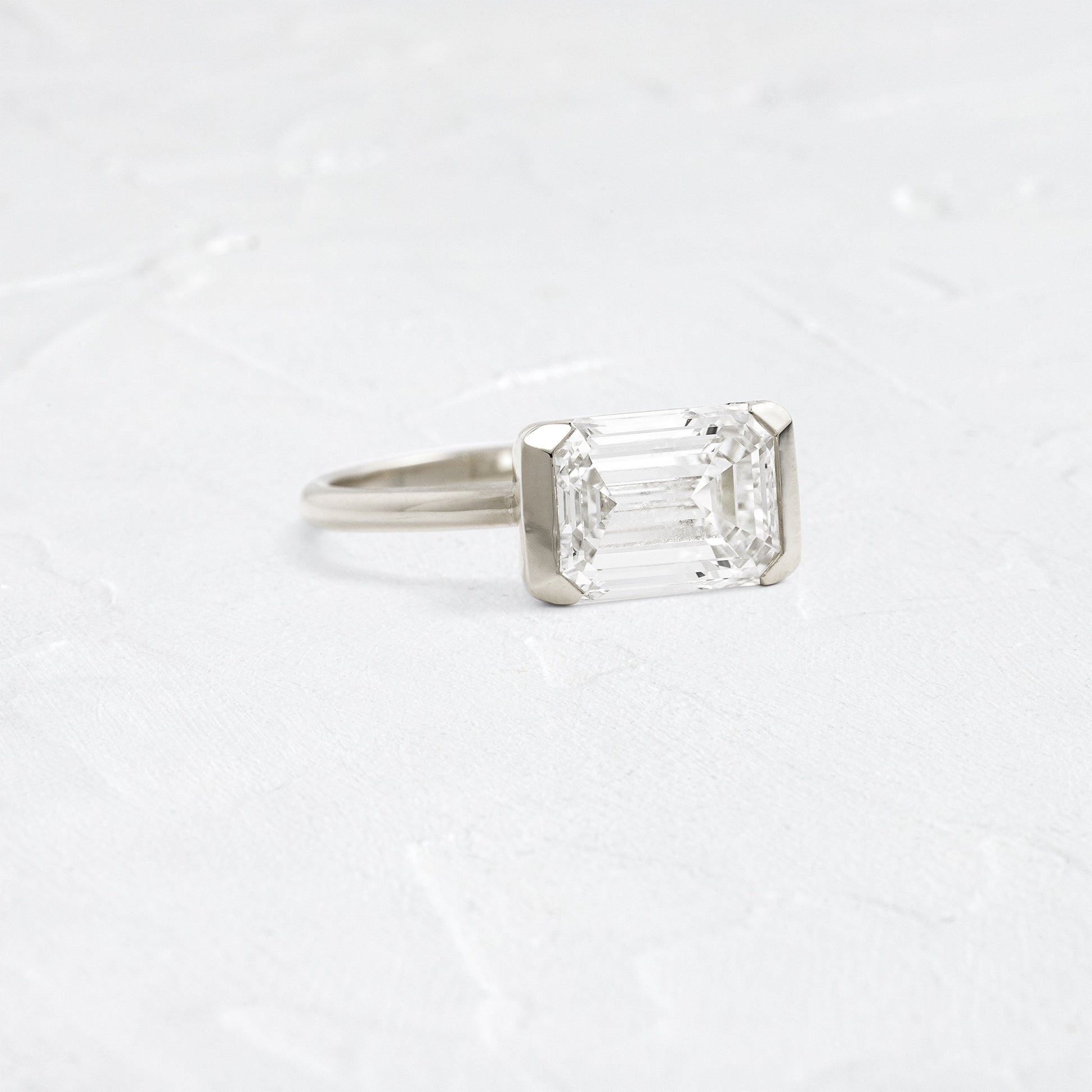East West Solitaire Half Bezel-Emerald Lab Grown Diamond Engagement Ring - Detail view