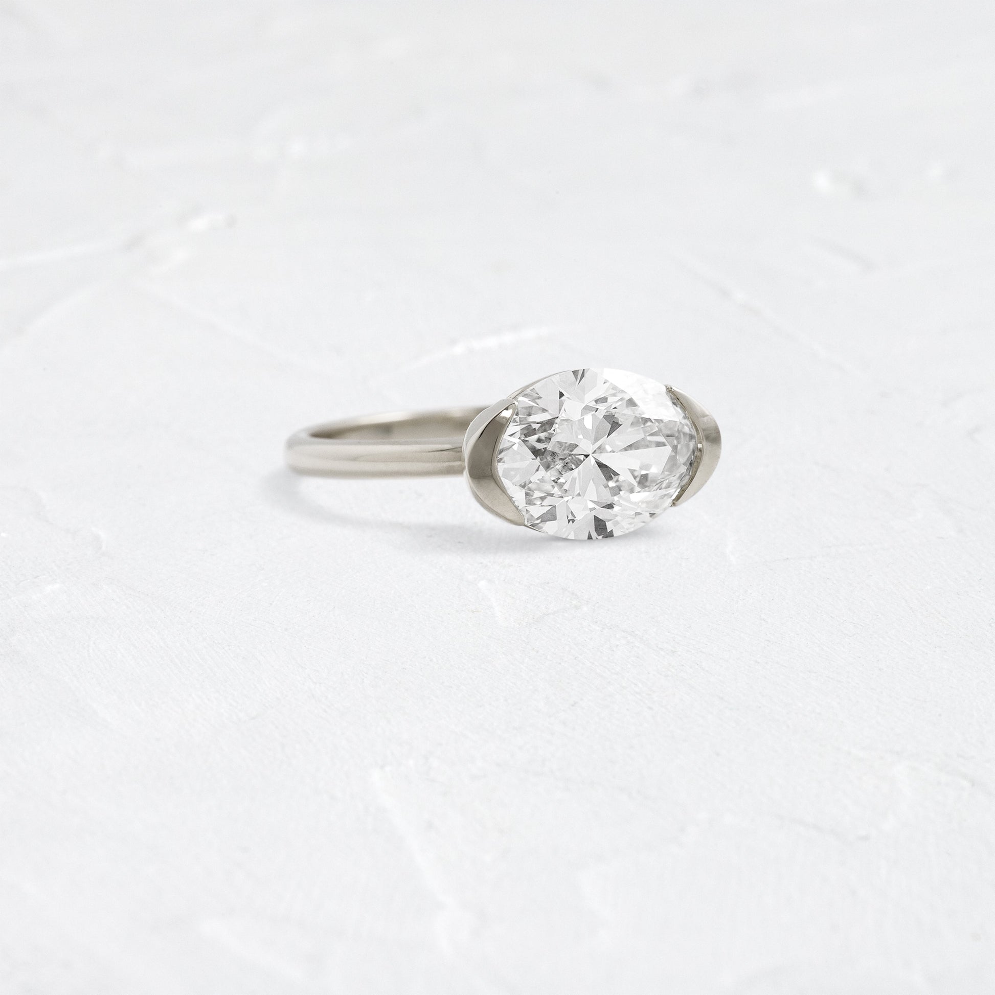 East West Solitaire Half Bezel-Oval Lab Grown Diamond Engagement Ring - Detail view