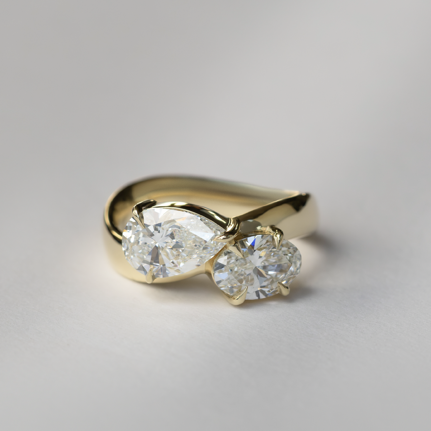 East West Toi Et Moi Curved Band- 1.33 CT Pear & 1.3 CT Oval Moissanite Engagement RingEast West Toi Et Moi Curved Band- 1.33 CT Pear & 1.3 CT Oval Moissanite Engagement Ring - Side view