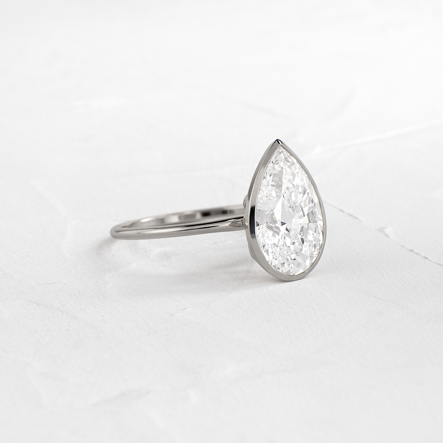 Solitaire Bezel with Hidden Stones-Pear Lab Grown Diamond Engagement Ring - On model
