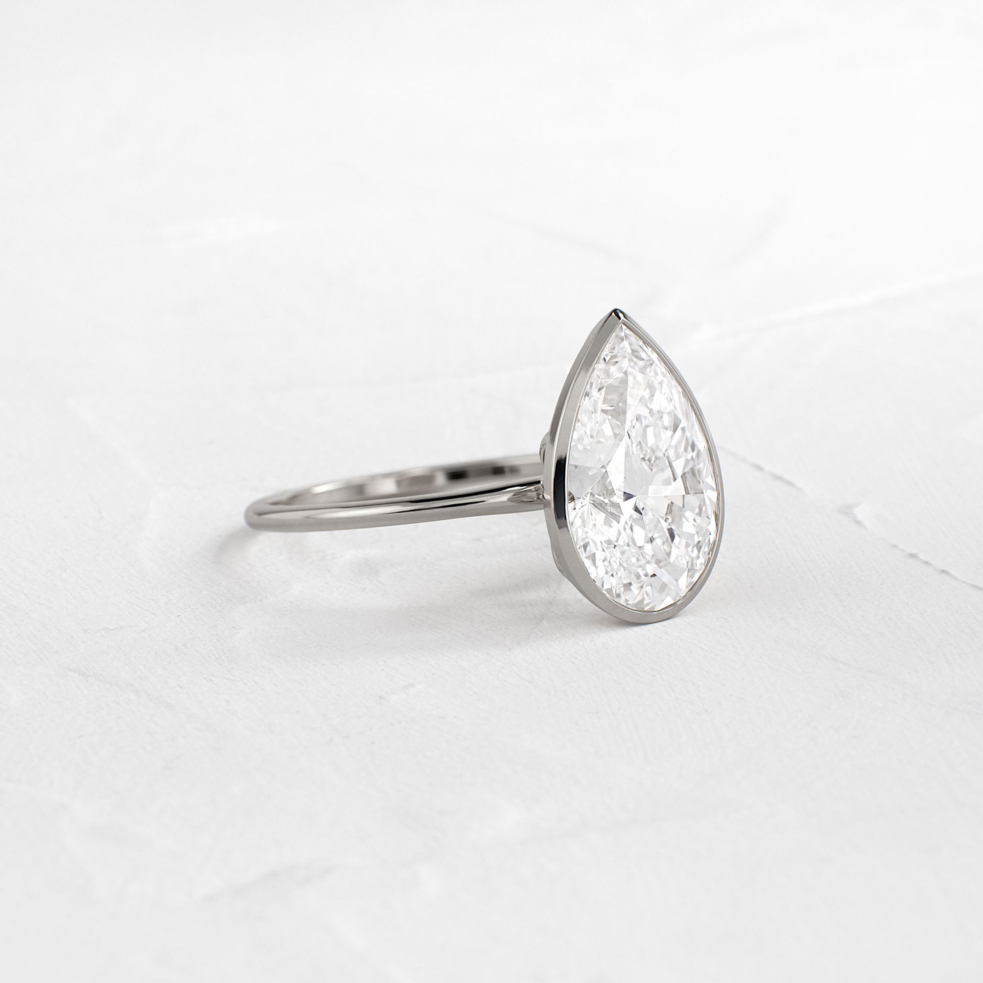 Solitaire Bezel with Hidden Stones-Pear Lab Grown Diamond Engagement Ring - On model