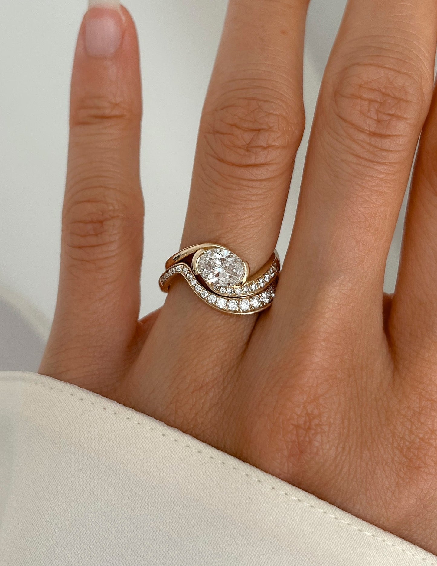 Solitaire Half Bezel Rapture & Pave Band- 1 CT Oval Lab Grown Diamond Bridal SetSolitaire Half Bezel Rapture & Pave Band- 1 CT Oval Lab Grown Diamond Bridal Set - On model