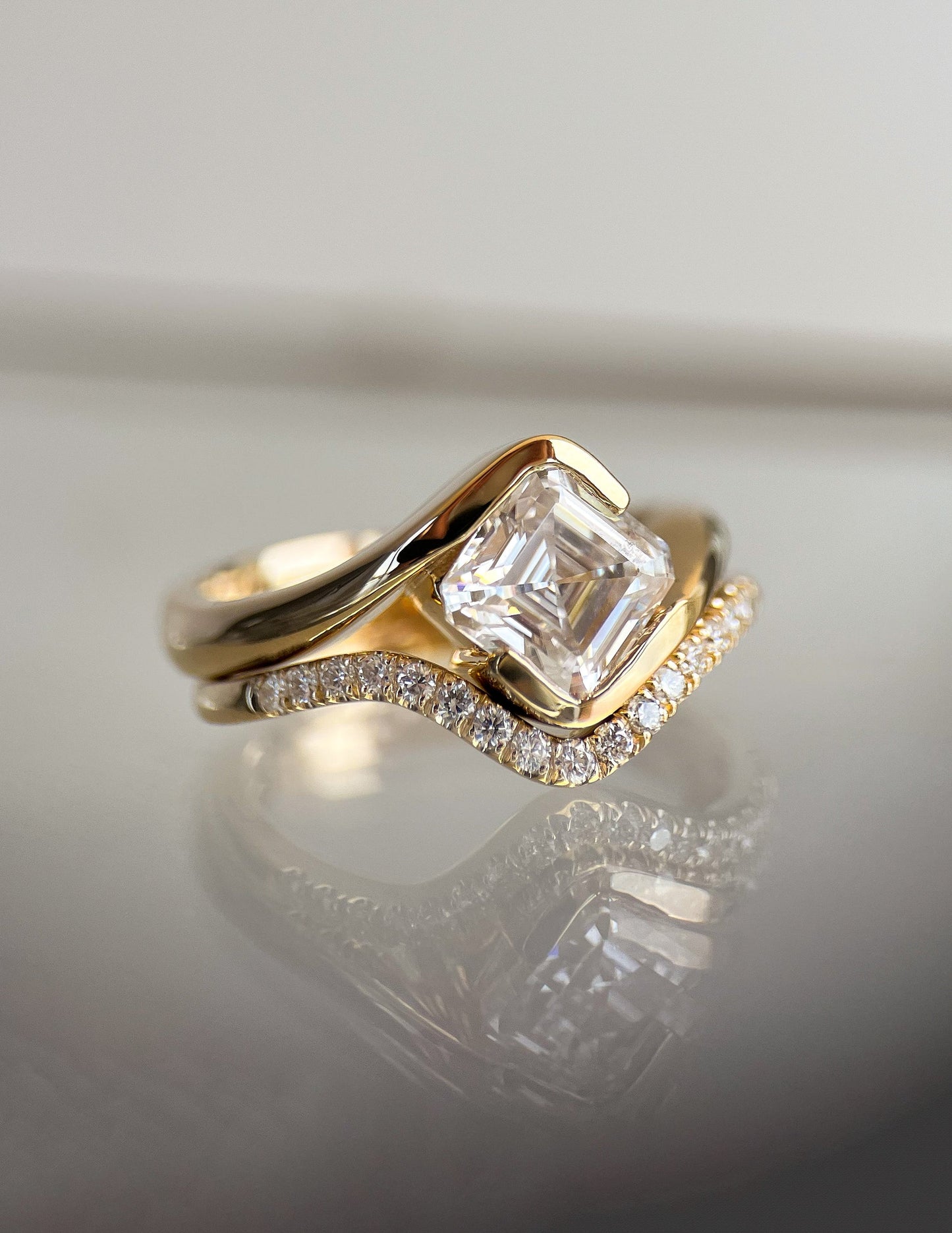 Solitaire Rapture Half Bezel & Pave Band- 1.5 CT Asscher Lab Grown Diamond Bridal SetSolitaire Rapture Half Bezel & Pave Band- 1.5 CT Asscher Lab Grown Diamond Bridal Set - On model